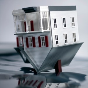 House turned upside down on reflective background.