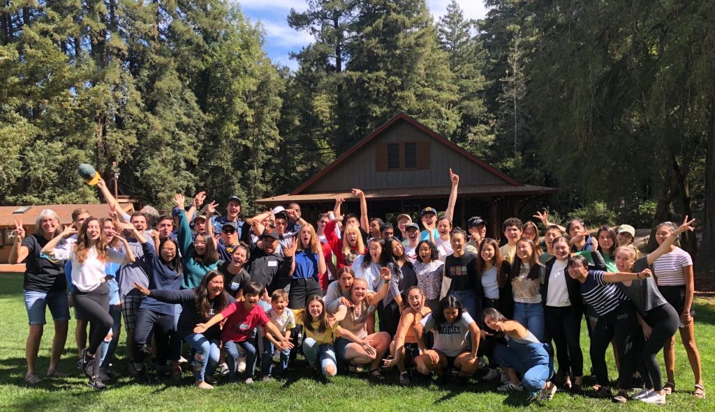 A group picture of about 50 students at a camp looking excited