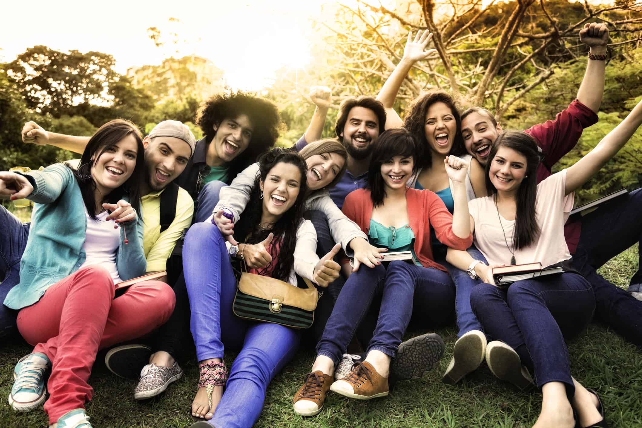 Multi-ethnic group of young students sharing and having fun at a university campus.