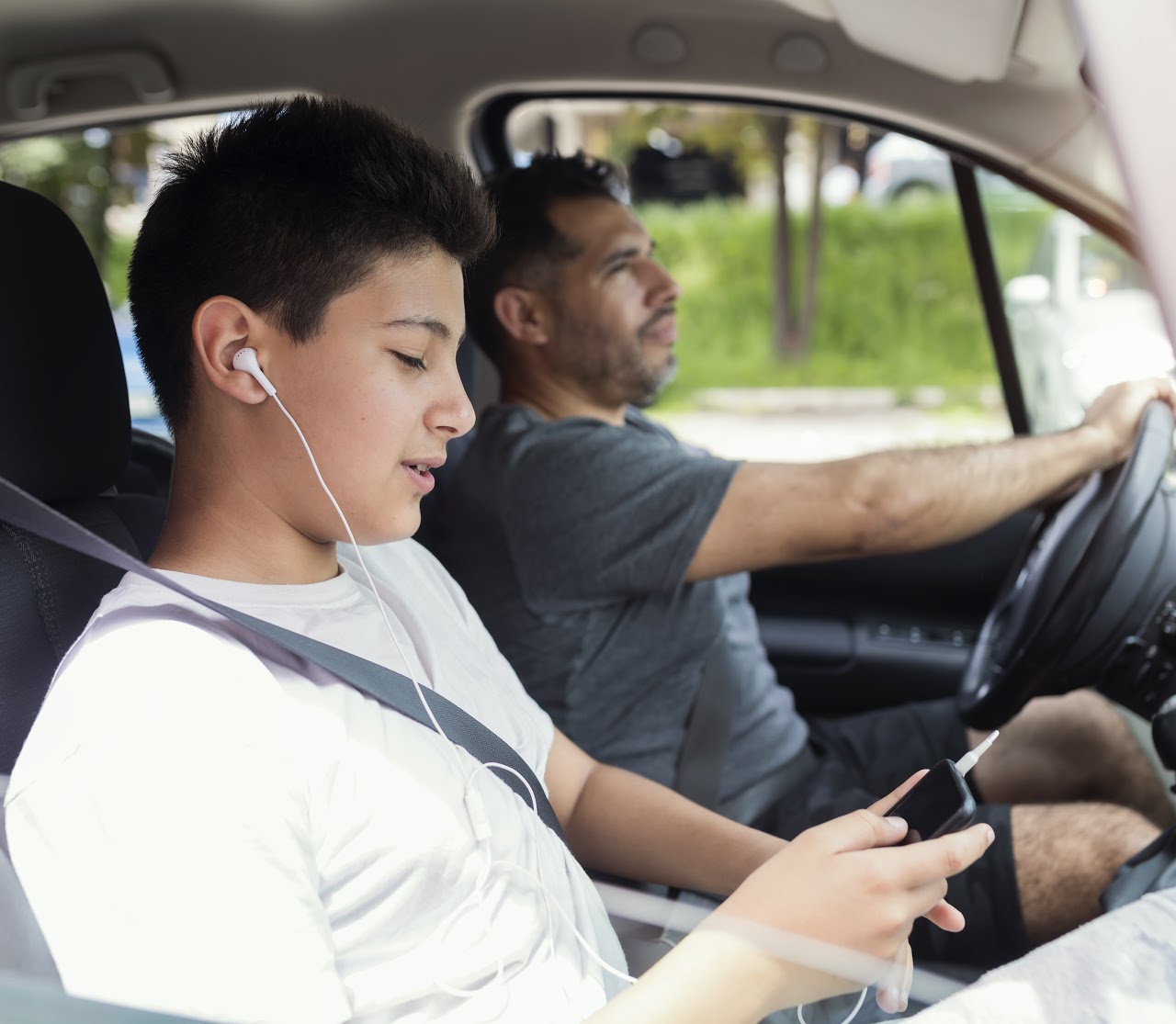 Father and son spending quality time together.Traveling by car and listening music.