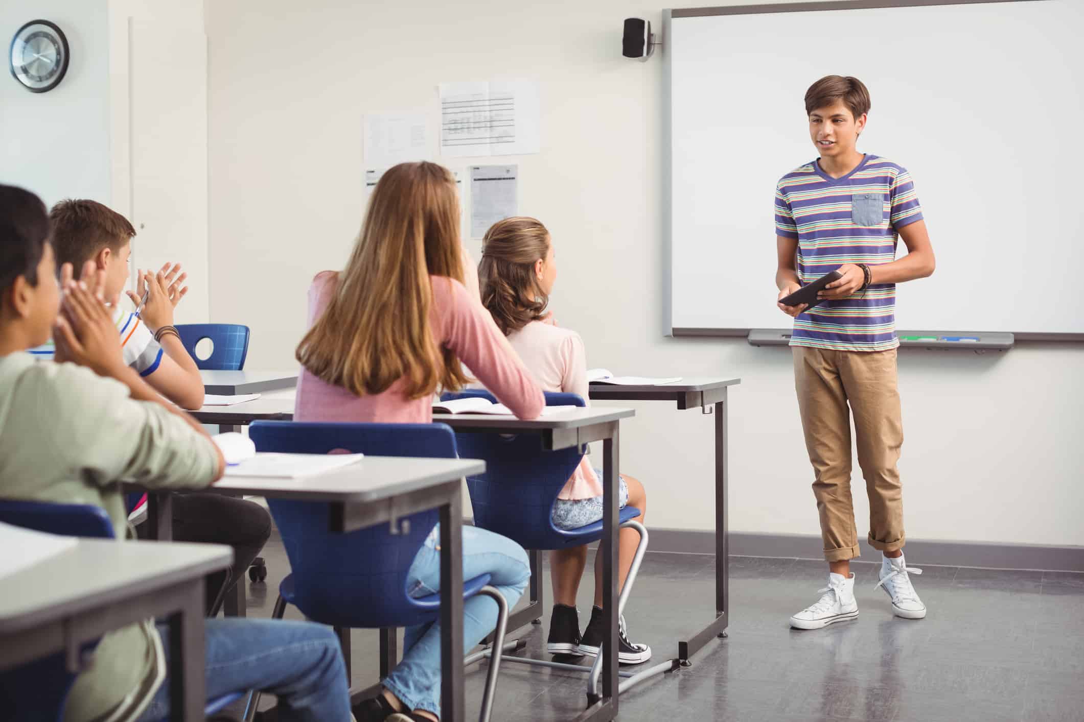 Schoolboy giving presentation in classroom at school
